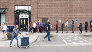 A line at Argonaut Wine and Liquors in Capitol Hill appeared soon after Mayor Michael Hancock announced a "shelter in place" order and quickly stretched around the building. March 23, 2020. (Kevin J. Beaty/Denverite)