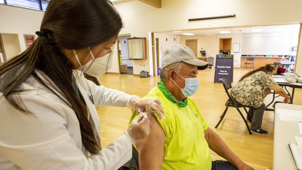 Nhung Mai gives Demetrio Rodriguez a COVID-19 vaccine at a city-run clinic inside the Barnum Recreation Center. March 10, 2021.