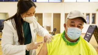 Nhung Mai gives Demetrio Rodriguez a COVID-19 vaccine at a city-run clinic inside the Barnum Recreation Center. March 10, 2021.