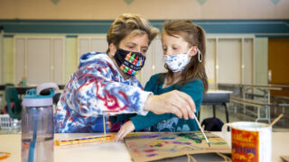 Jennifer Piel, leader of Carson Elementary's Discovery Link before- and after-school program, paints with Helen after regular classes ended on March 17, 2021.