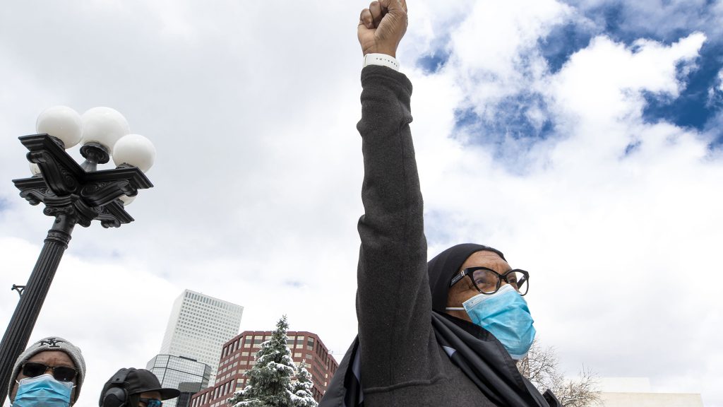 Alice Hayes raises a fist during the first of two protests at the Capitol against police brutality. April 17, 2021.