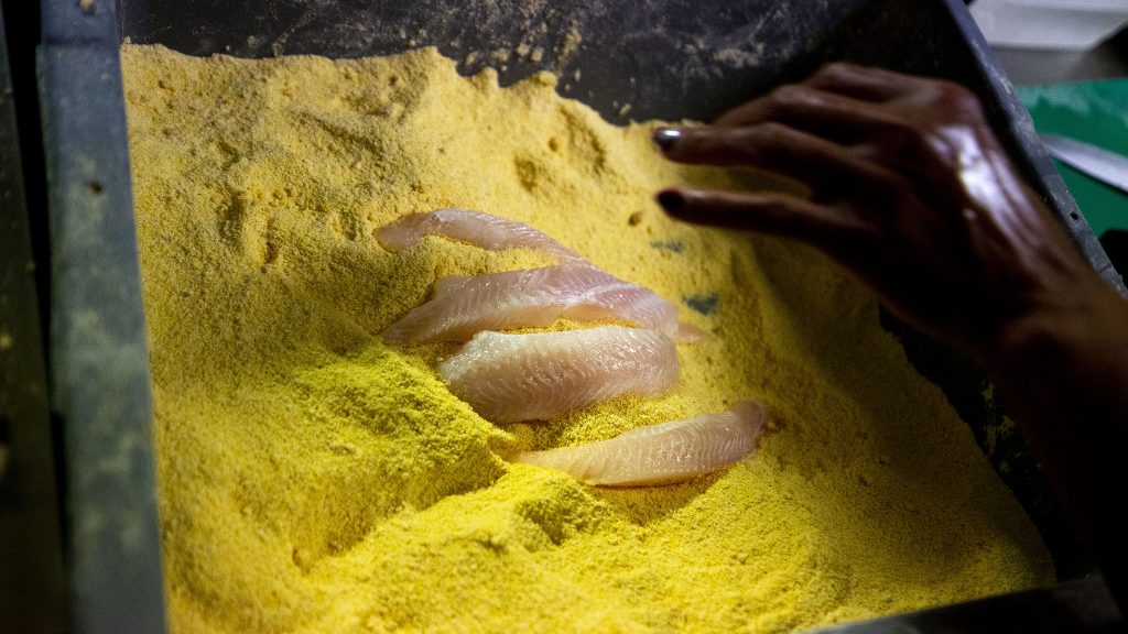 Chef Tammy Johnson breads catfish during the lunch rush at Welton Street Cafe. May 8, 2021.