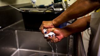 Mamie Henry sqeeze water out of a rag as Welton Street Cafe's dinner rush fades. May 8, 2021.