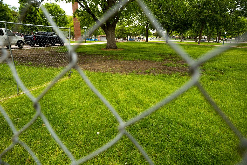 A patch of dirt shows where a large encampment once sat at Veterans Park at Colfax Avenue and Lincoln Street. It's been fenced off since the city swept the camp. May 27, 2021.