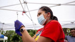 Robin Cothley, with Denver Indian Health and Family Services, prepares a Johnson and Johnson COVID-19 vaccine during the talking circle at Governor's Park. June 10, 2021.