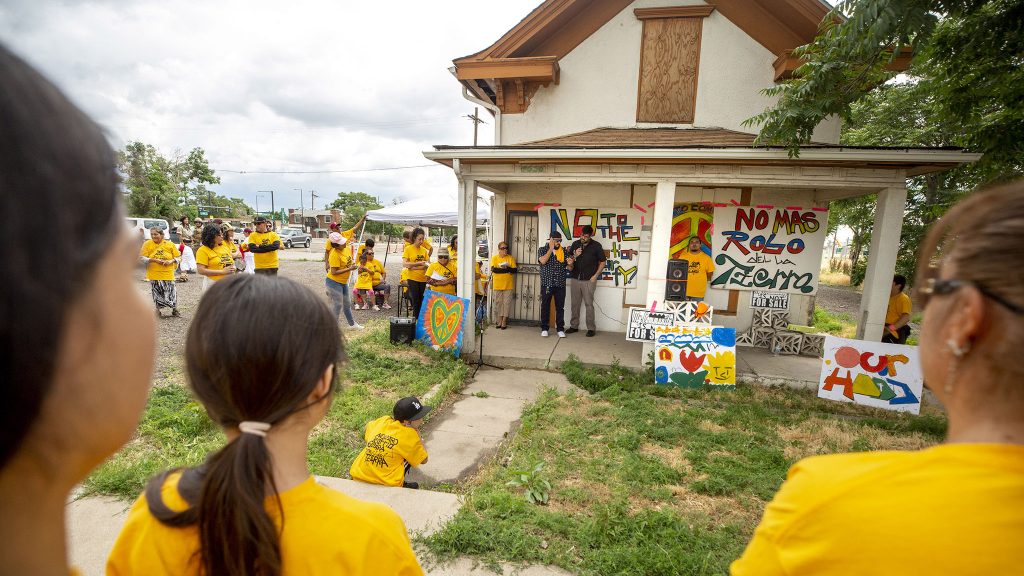 David Torres speaks from the porch of his old family home during a protest against public-private partnerships on the "Triangle" parcel of the National Western Center development site. June 26, 2021.