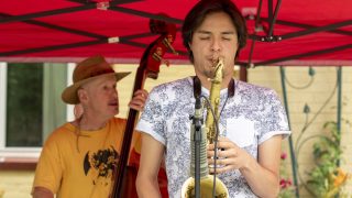 Rico Jones plays a front-lawn concert with Bill McCrossen (left) and Vlad and Aleks Girshevich across the street from Sloan's Lake. July 2, 2021.
