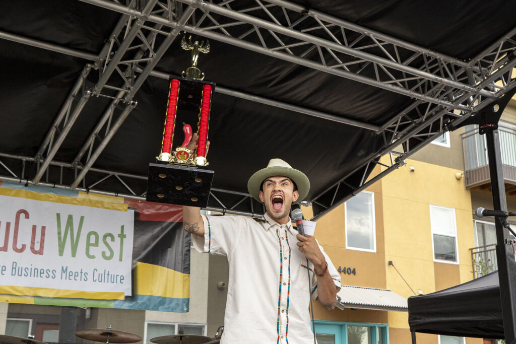 Diego Florez hollers as he holds up the top trophy for the Westwood Chile Fest's chile eating contest . Sept. 11, 2021.