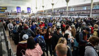 Passengers throng the Great Hall at Denver International Airport as they wait to pass through the south security checkpoint on Friday, October 22, 2021.