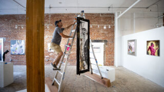 Brett Matarazzo tweaks a hanging piece made for Interplay – Art + Opera at the BRDG Project. Oct. 7, 2021.