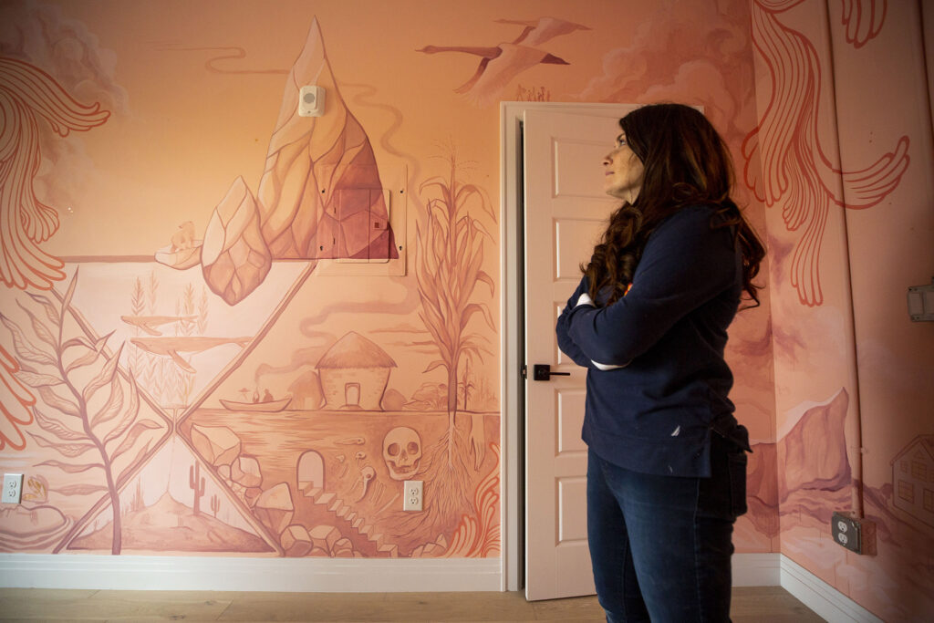 Christina Eisenstein, co-owner of the Acoma House hotel, stands in a room painted by Lindy Zimmer.  October 21, 2021.