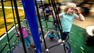 Bonnie (8) rides a fast-moving merry-go-round like a sea captain at the new City Park playground. Oct. 26, 2021.