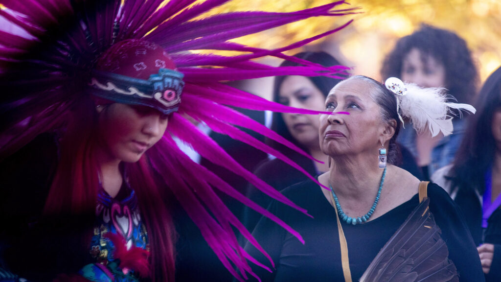 CU Denver doctoral student Christina Sigala watches Aztec dancers during a celebration of new scholarship opportunities for decendants of people forced out of Auraria in the 1960s to make way for the shared campus that exists there today. Nov. 4, 2021.