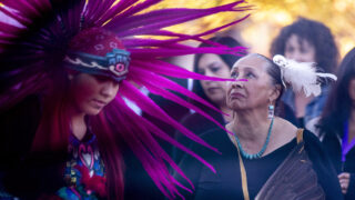 CU Denver doctoral student Christina Sigala watches Aztec dancers during a celebration of new scholarship opportunities for decendants of people forced out of Auraria in the 1960s to make way for the shared campus that exists there today. Nov. 4, 2021.