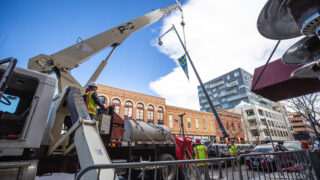 Workers install a light pole on Wazee Street downtown. Nov. 23, 2021.