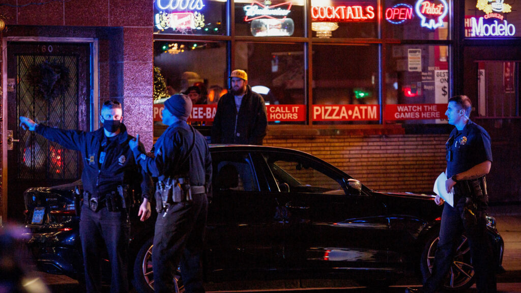 Law enforcement officers on Broadway near 1st Avenue in Denver on December 28, 2021, near Sol Tribe Custom Tattoo and Body Piercing, owned by tattoo artist and muralist Alicia Cardenas.