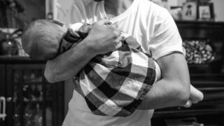 M. holds his infant daughter in the home he now shares with the Cheverton family. Dec. 22, 2021.
