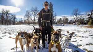 Felix Merino stands with eleven dogs, including Opal, Johnny, Waffles, Pedro, Lars, Sansa, Luna and Nina, during a walk at City Park. Jan. 4, 2022.