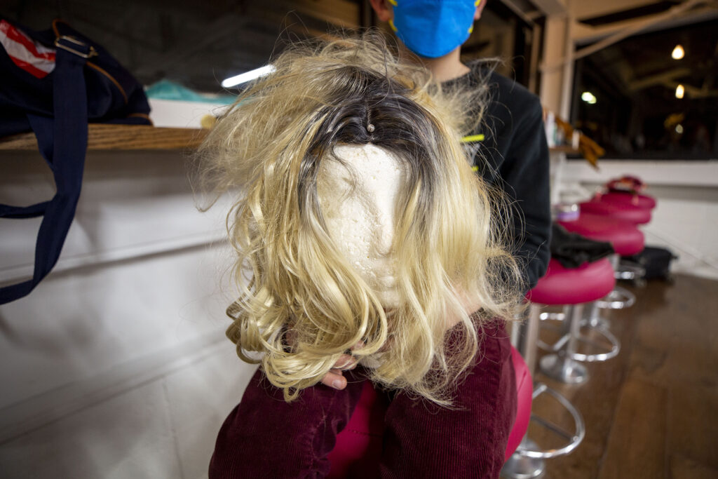 A student in Charlie Fleming's, AKA Diamond Starr's, Drag Teen-Tween Fashion class holds a foam head with a wig. Jan. 13, 2022.