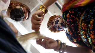 Charlie Fleming, AKA Diamond Starr, helps Aeshleigh Sheren learn their way around a wig during Fleming's Drag Teen-Tween Fashion class held in Stanley Marketplace's Factory Fashion. Jan. 13, 2022.