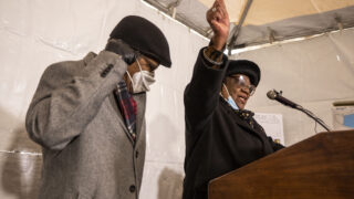 Eddie Woolfolk cheers the groundbreaking of the Charity's House affordable housing building on Welton Street, during a press conference, with her husband, Robert. Jan. 21, 2022.