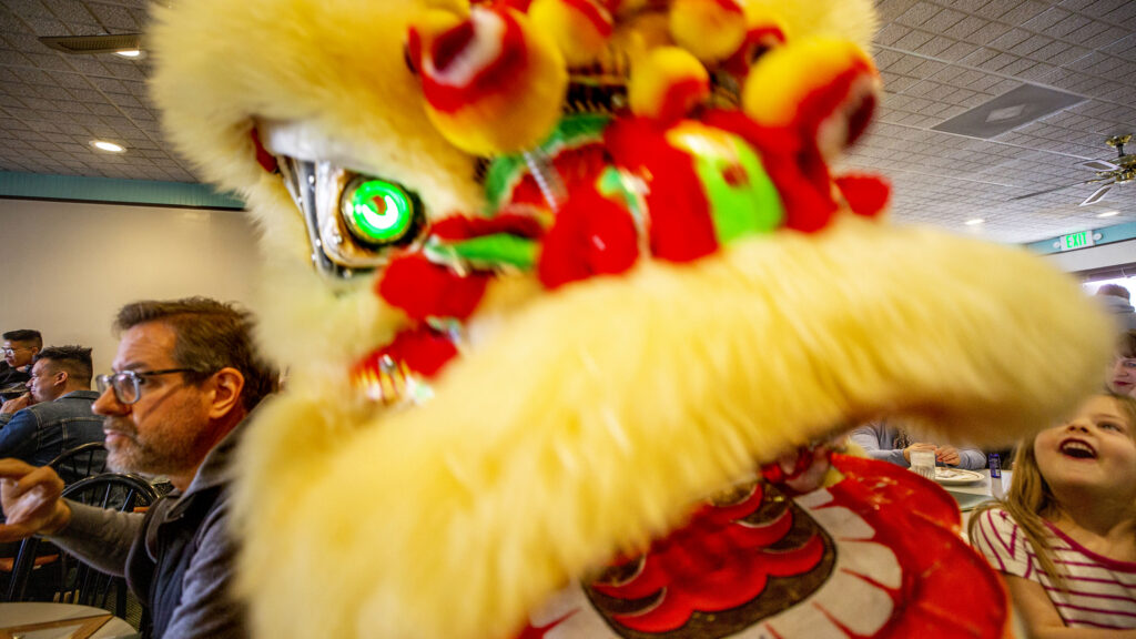 Lion dancers with Shaolin Hung Mei Kung Fu march around China Jade Restaurant during Lunar New Year festivities at Federal Boulevard's Far East Center. Feb. 5, 2022.