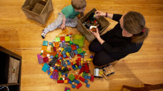 Beatrice Scheuermann and her son, Hans, play on the floor in their Congress Park home. March 22, 2022.