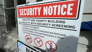 A pocket knife sits on top a sign outside the City and County Building in Denver showwing banned items on Wednesday, April 13, 2022. (Esteban L. Hernandez/Denverite)