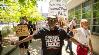 Jerry Burton leads a march protesting ten years of Denver's urban camping ban, the last day in a week of events decrying the "decade of doom." May 14, 2022.