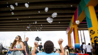 A kid reaches for bubbles at Sun Valley Rising's Viaduct Night Market beneath Colfax Avenue. May 14, 2022.