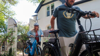 Stephanie Vail and Pete Winterscheidt wheel their electric bicycles to the front yard of their Sloan's Lake home in Denver on Sunday, May 15, 2022.