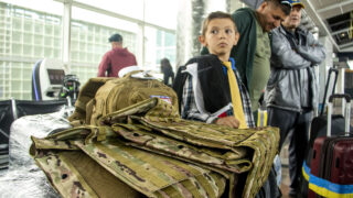 Nazar Radchenko leans on a flack jacket and suitcases filled with supplies that his family will take with them Poland and Ukraine. May 24, 2022.
