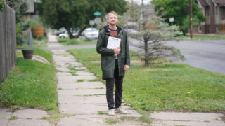 Jonathan Pira in his West Colfax, Denver, neighborhood, May 31, 2022, as he goes door to door collecting signatures for a ballot measure that would that would raise fees to fund the construction and repair of sidewalks across the city.