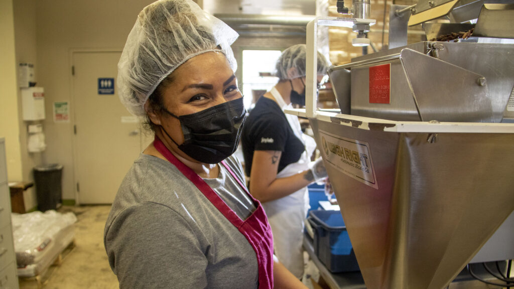Rocio Reza runs the bean machine at the Women's Bean Project headquarters in Five Points. June 9, 2022.