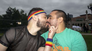 James Pablo and Jonathon Torres kiss on the Civic Center Park lawn during Denver PrideFest. June 25, 2022.