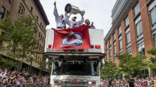 The Colorado Avalanche's Nathan MacKinnon holds the Stanley Cup above his head during a parade celebrating the team's win. June 30, 2022.