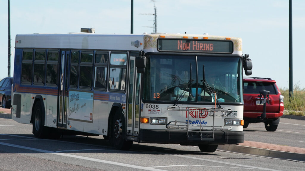 An RTD bus with a NOW HIRING sign on Federal Boulevard in Denver, Aug. 12, 2022.