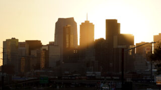 Morning sun pierces the haze around the Denver skyline, seen from the west, Aug. 12, 2022.