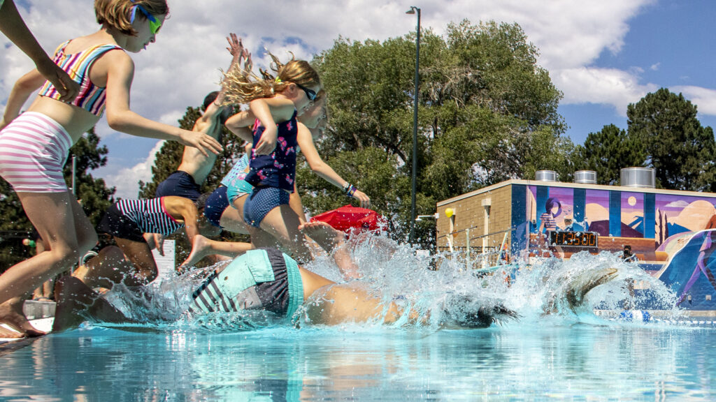 Kids leap into the newly renovated Congress Park pool. Aug. 2, 2022.