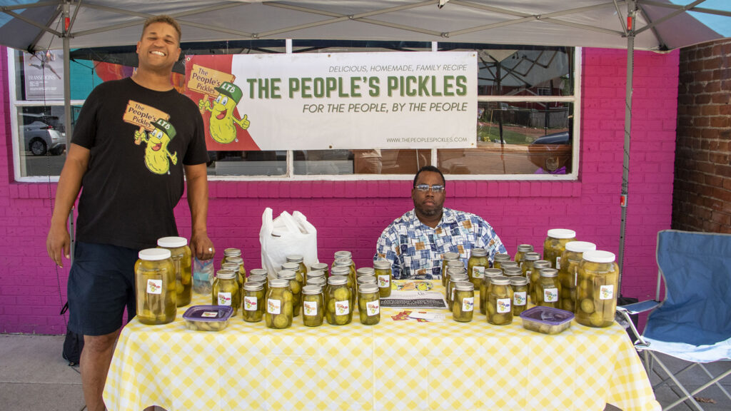 Marcus Weaver (left) and Raymond Johnson under their People's Pickles tent at Brother Jeff Fard's Black Dollar Saturday event on Welton Street. Aug. 13, 2022.