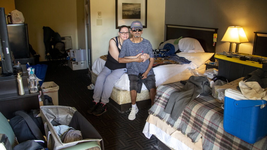 Mikey and Dawn Martinez sit in the Jefferson Park Quality Inn hotel room where they've been living for months. Aug. 29, 2022.
