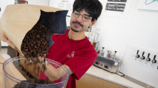Denver’s Prodigy Coffee has opened a second cafe, this time at Broadway and 45th in Globeville. Alex Villalpando tops off the bean grinding machine on Sept. 28, 2022.