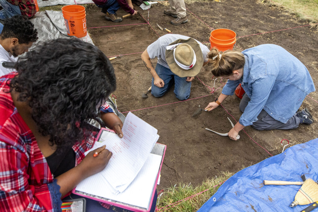 Community College of Denver student Daunita Lewia (left to right) takes notes as her classmates, Jeff Sapp and Marissa Erickson excavate a section of Denver's Auraria Campus. Sept. 9, 2022.