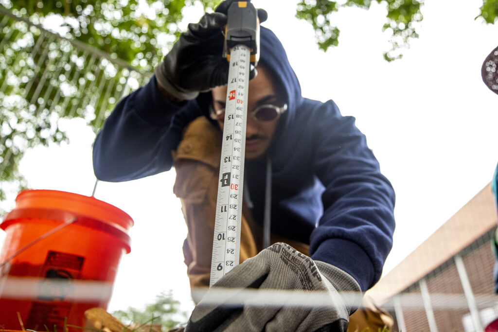 Metropolitan State University student Jaylon Dodge measures into an excavation site he and his classmates are digging into on Denver's Auraria Campus. Sept. 9, 2022.