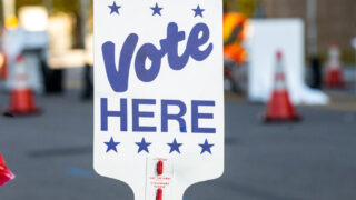Early voters drop off their ballots at a drive-through collection station outside Denver Elections Division headquarters on Bannock Street, Nov. 7, 2022.
