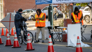 Early voters drop off their ballots at a drive-through collection station outside Denver Elections Division headquarters on Bannock Street, Nov. 7, 2022.
