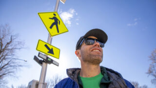 Avi Stopper stands in front of a new crosswalk signal on York Street, by the Denver Botanic Gardens. Nov. 16, 2022.
