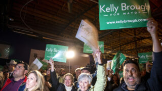 Supporters wave signs during a launch party for Kelly Brough's mayoral campaign at the Blue Moon Brewery off Brighton Boulevard. Nov. 16, 2022.