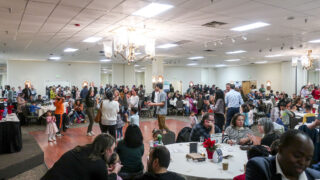 Attendees of the Refugee First Thanksgiving in Aurora mingle during the event on Nov. 21, 2022. Organizers put the dinner together each year to create a welcoming space for the Denver metro area’s growing refugee community.