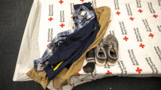 Someone's belongings on a cot inside an emergency shelter for people arriving from the southern U.S. border, set up at a Denver rec center. Dec. 13, 2022.